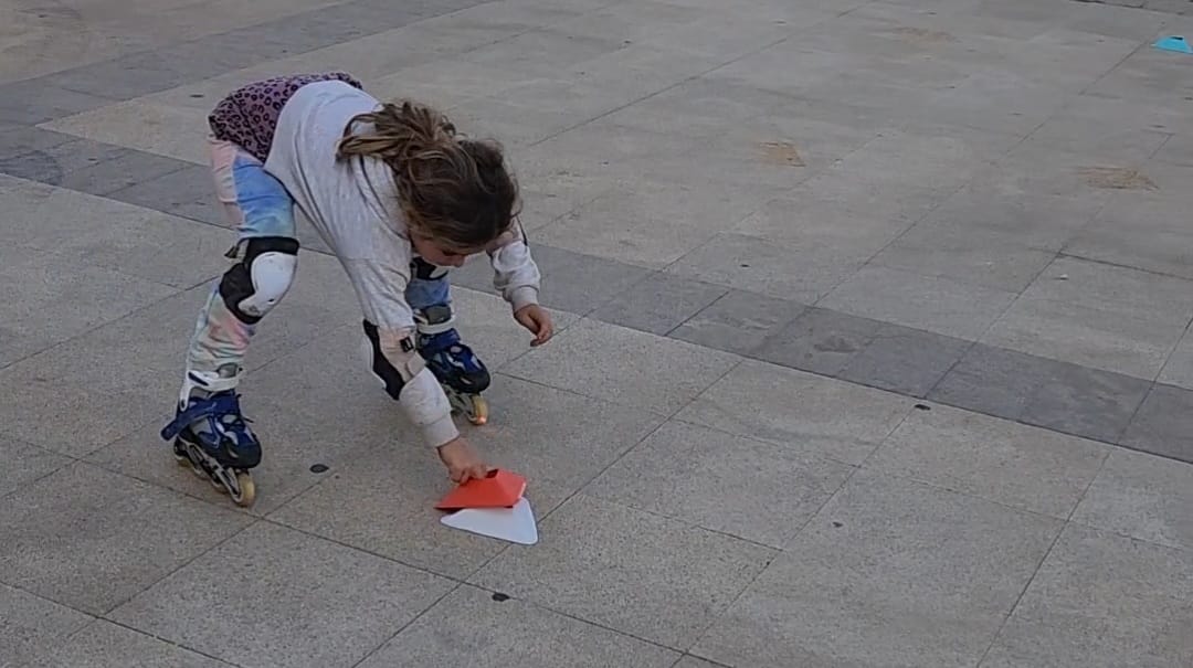 Young children learning to balance on rollerblades on flat surface
